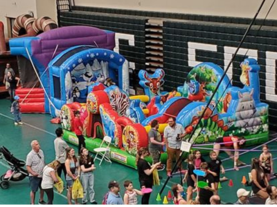 Indoor school event with inflatables and crowds of families